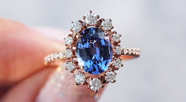 Blue Tanzanite engagement ring with diamonds surrounding and diamond band