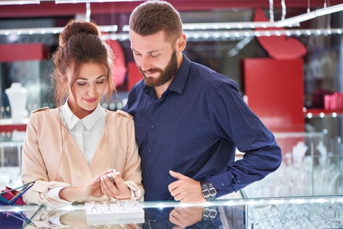 A Man and Woman shopping for an engagement ring in a jewelry store