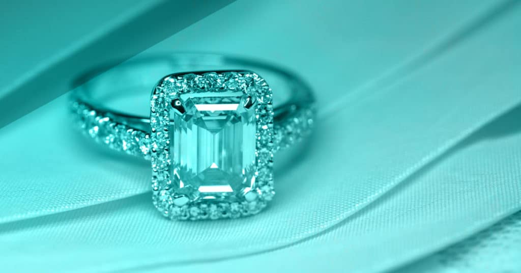 halo engagement ring with emerald cut center stone