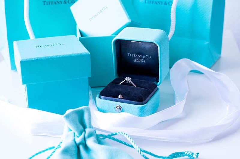 diamond engagement ring in open Tiffany box with empty Tiffany boxes and white tulle