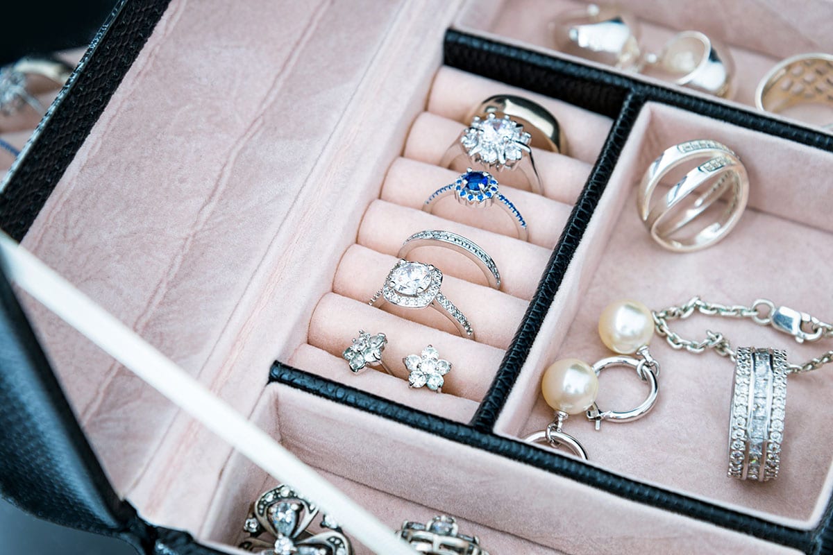 close up of rings and earrings inside a lined jewelry box