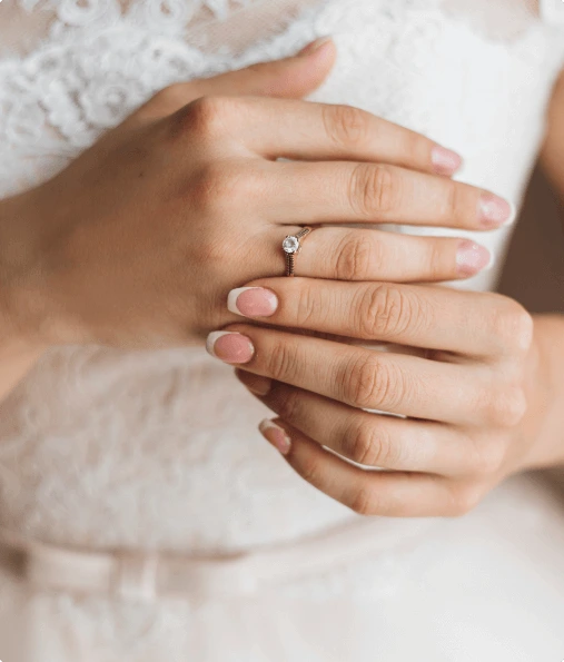 hands-bride-with-tender-french-manicure-precious-engagement-ring-with-shiny-diamond-wedding-dress