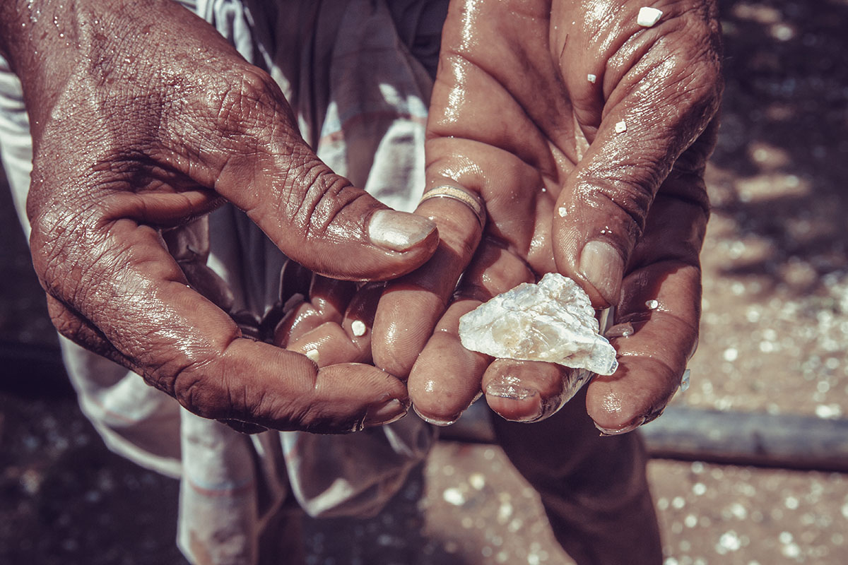 Worker’s hands holding rough diamond