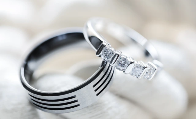 silver platinum and titanium diamond wedding rings on white rope background