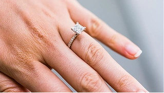 A person shows off their diamond engagement ring.