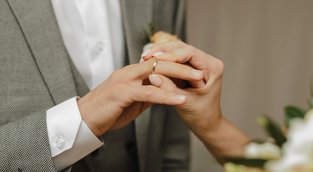 Man sliding diamond ring on woman’s finger