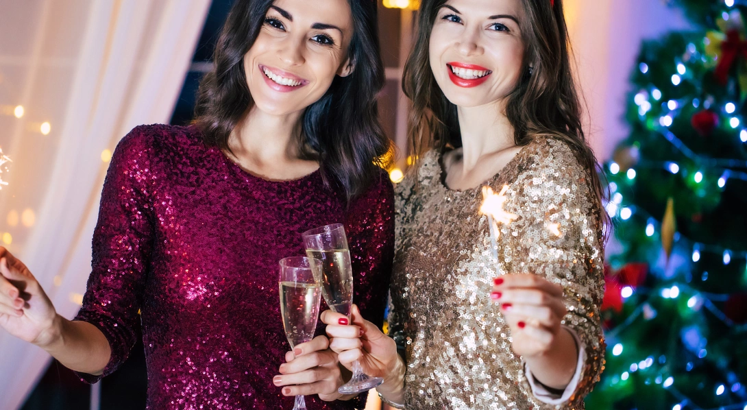Women holding sparklers wearing sparkly dresse