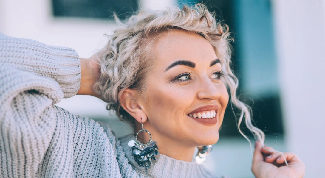 Woman in chunky sweater and dangling earrings