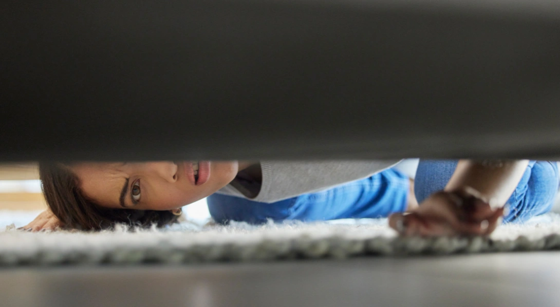Woman looking under couch