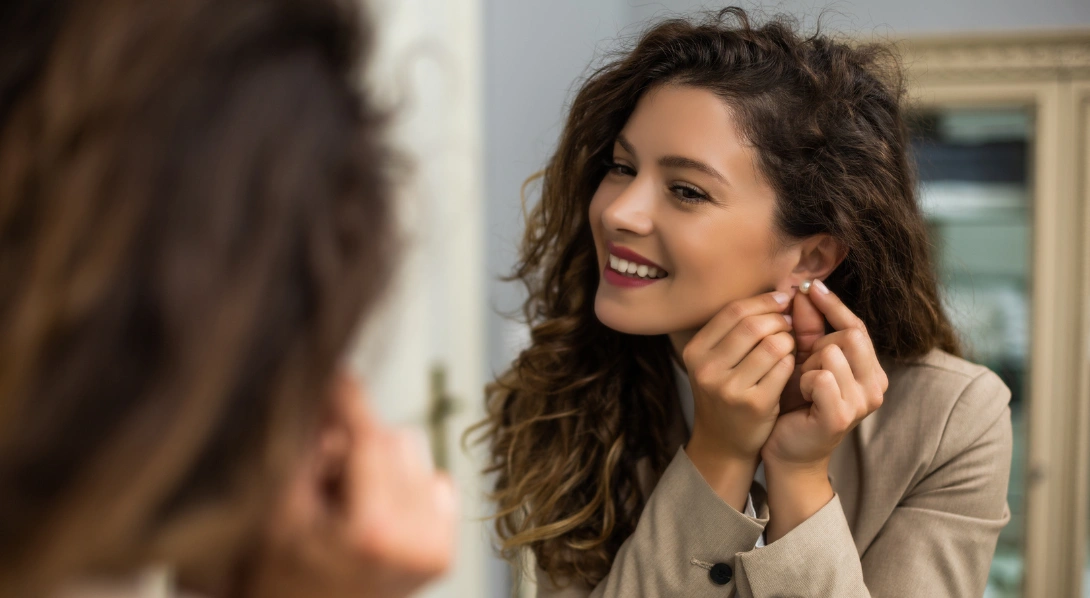 Woman putting on earring