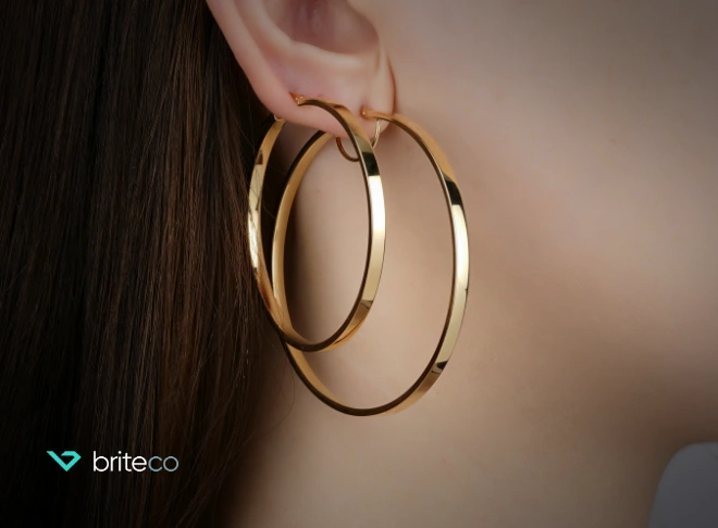 Side shot of gold earring in woman’s ear