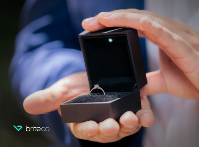 Man holding jewelry box with engagement ring inside open