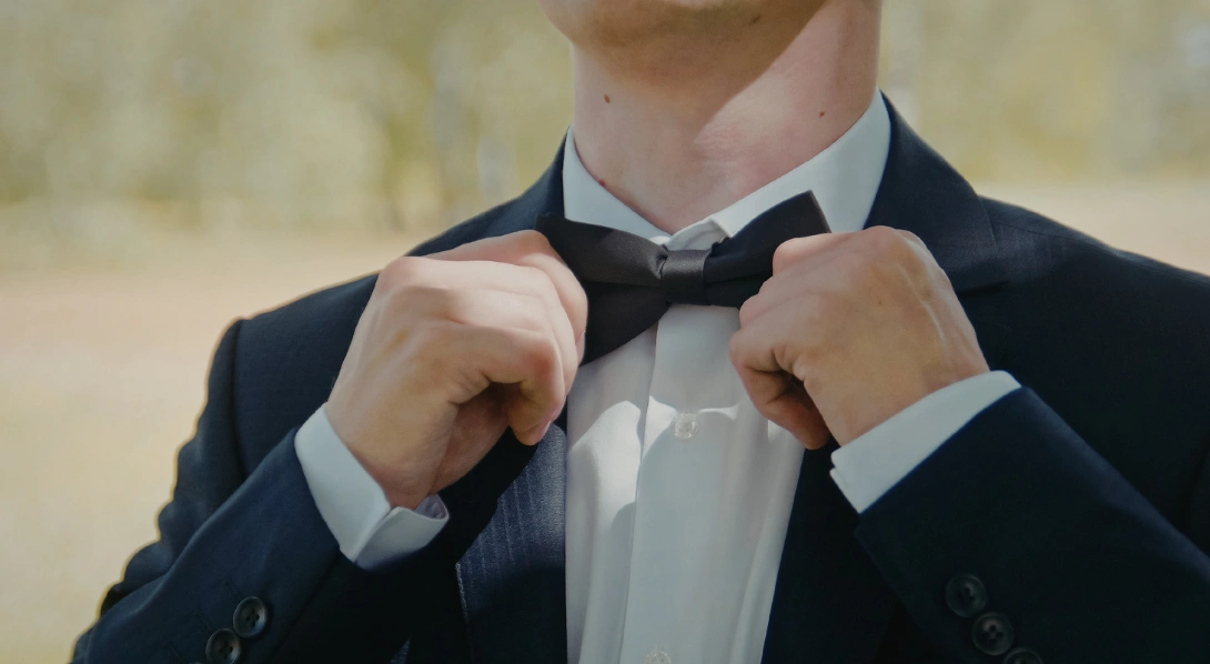 Groom adjusting bowtie