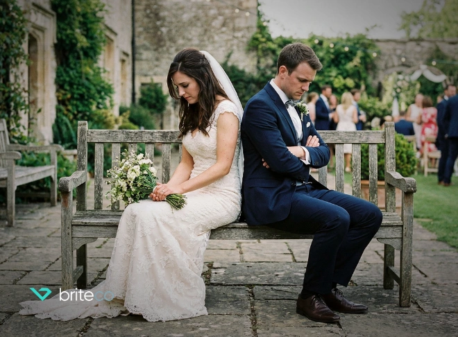 Unhappy bride and groom sitting facing away from each other