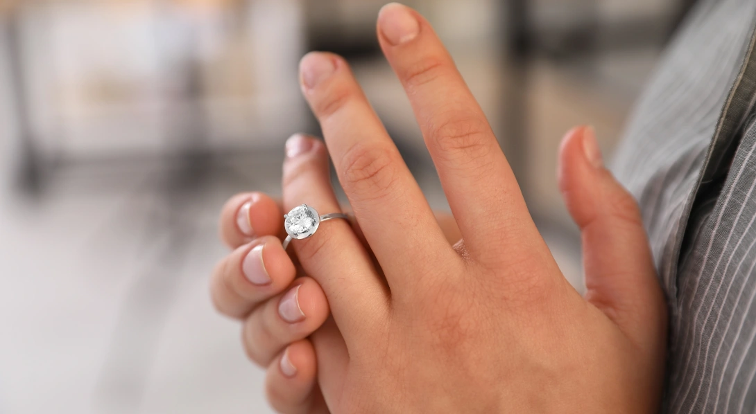 Woman sliding ring off hand